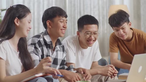 Enthusiastic Students Collaborate on Laptop Project Together