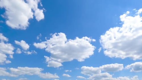 Puffy white clouds appearing in the blue clear sky. Picturesque timelapse quickly moving