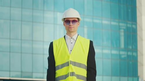 Portrait of a Successful Young Male Engineer or Architect Wearing in Helmet and Safety Jacket
