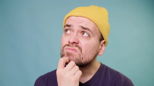 A Studio Shot of a Male Guy with a Confused Expression Making a Funny Face As If He's