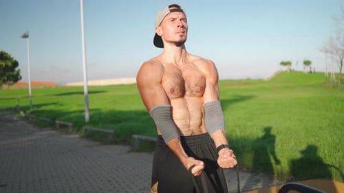 Muscular Man Exercising with Band Outdoors