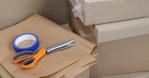 Different packaging materials and scissors, closeup. Camera moving forward