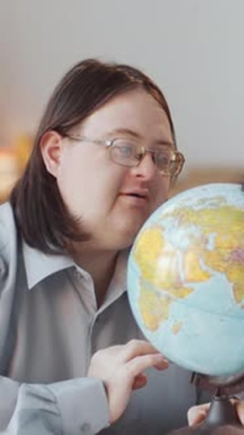 Woman Studying Globe in Indoor Setting