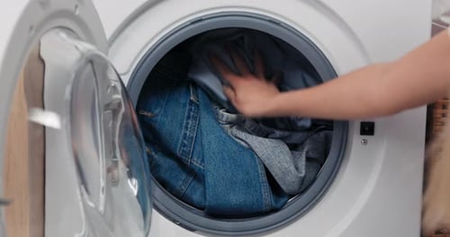Closing Washing Machine Full of Clothes for Cleaning