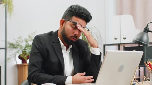 Tired Indian Business Man Suffering From Headache Problem Tension Migraine Stress at Home Office