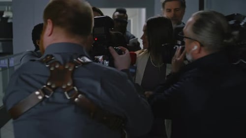 Woman Giving Interview to Reporters in Hallway