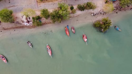 Aerial view of the fishing boats on tropical sea coast with sandy beach at sunset. Asian Fishing Boa