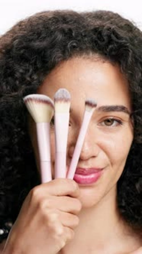 Makeup, brush and woman with smile, face and tools for beauty, studio and self care with foundation