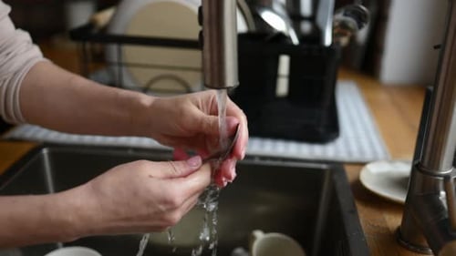 Girl Washing Dishes at Kitchen at Home