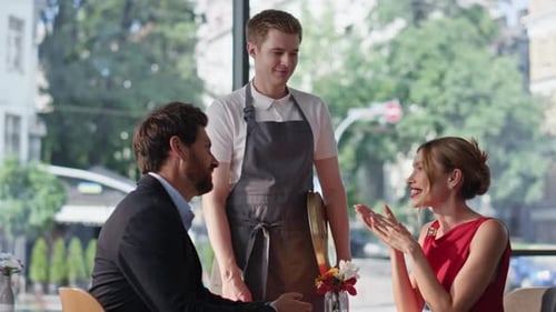 Friendly Waiter Taking Order in Happy Romantic Couple at Modern Cafeteria