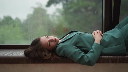 Woman Resting by a Rainy Window