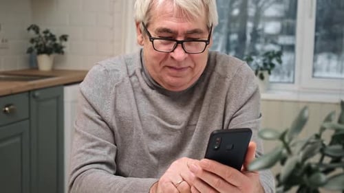 Senior Man Using Smartphone Indoors