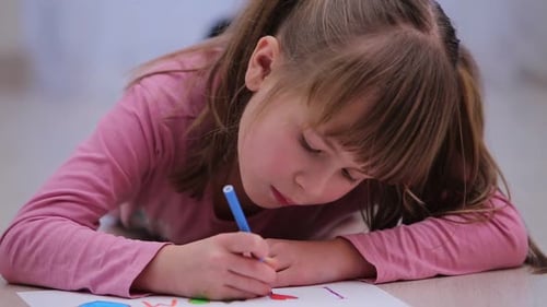 Girl Drawing Pictures with Markers on Floor