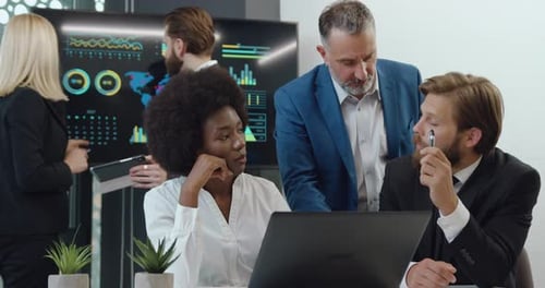 Diverse Team Collaborates on Project in Modern Office