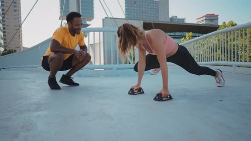 Woman Working Out with Personal Trainer in City