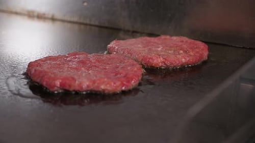 Closeup of Two Meat Burgers Fried in the Kitchen of the Restaurant