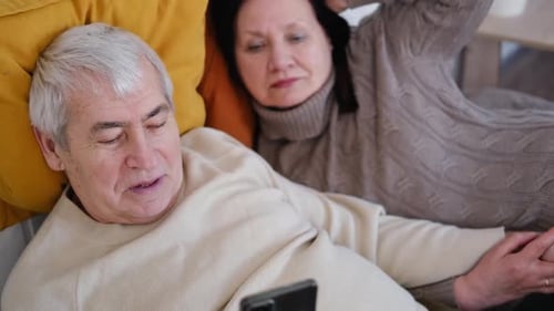 Senior Couple Relaxing at Home, Looking at Phone