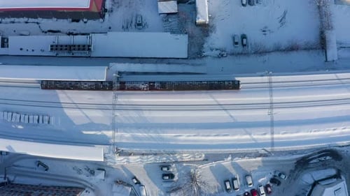 Aerial view around a train in winter. Drone view of trains at the railway station