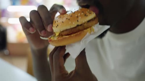 Close Up of Hungry Man Holding Burger with Two Hands Before Taking First Bite