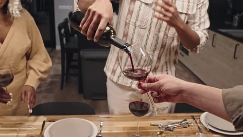 Mann gießt Wein ins Glas