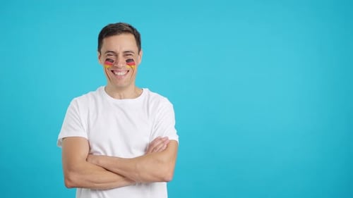 Smiling Man with Arms Crossed and Painted Cheeks