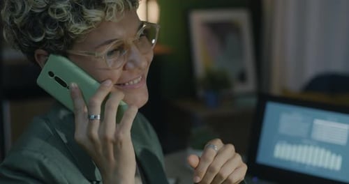 Woman Talking on Phone While Working at Night