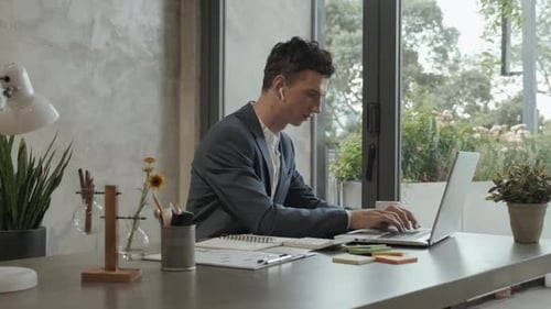 Man Working on Laptop in Modern Office