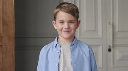 Smiling blonde boy in a bright indoor setting