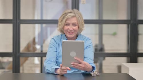 Woman Video Conferencing On Tablet in Office
