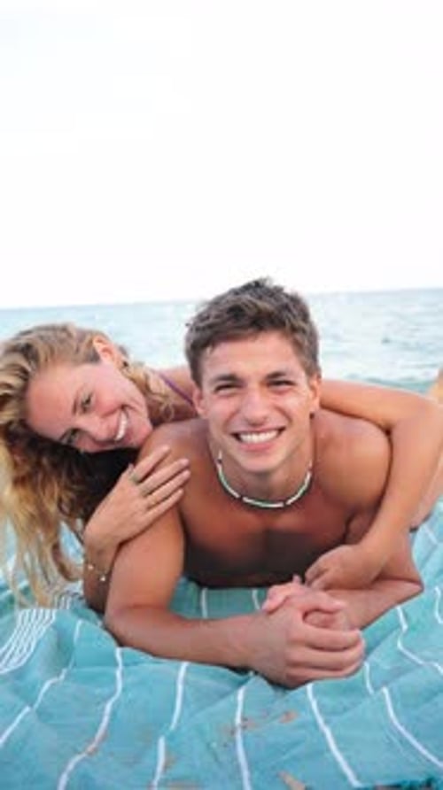Joyful Couple Enjoying a Sunny Beach Day While Laughing and Embracing Each Other By the Sea