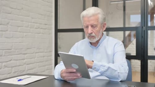 Senior Businessman Using Digital Tablet in Office