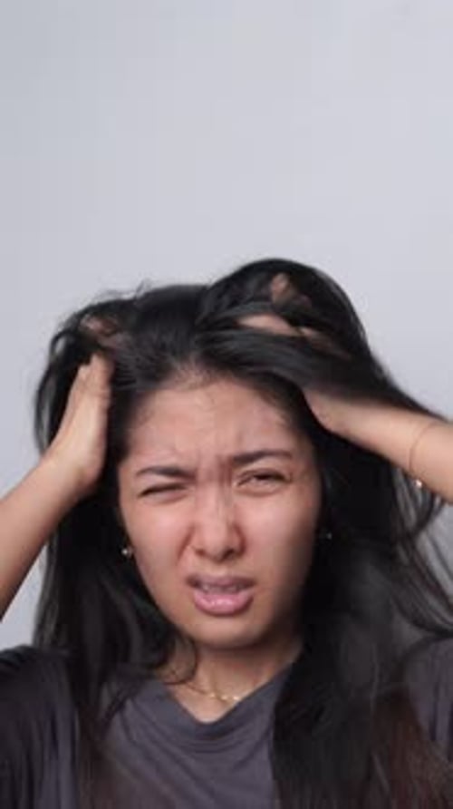 Woman with Long Hair Scratching Scalp in Frustration