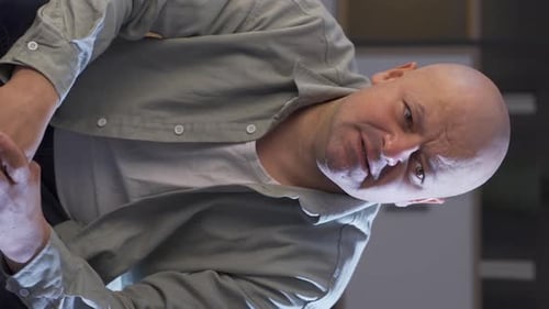 Vertikales Video eines depressiven weinenden Mannes allein zu Hause.