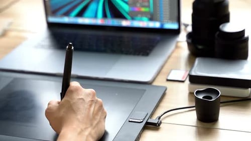 Hand using Stylus on Graphics Tablet at Desk