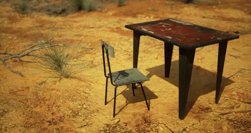 Abandoned Table and Chair in a Desolate Landscape During Daylight