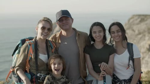Front View of Happy Family Hiking Together Standing on Cliff