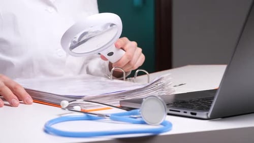 Doctor Examining Medical Records with Magnifying Glass in Clinic
