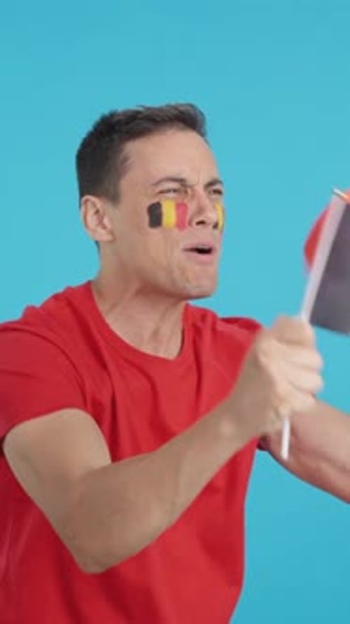 Enthusiastic Man Celebrating with Flag and Face Paint