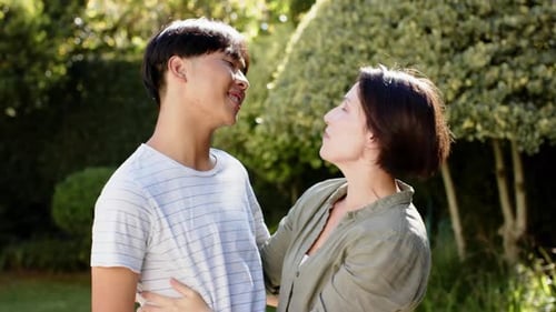 Happy Young Adult and Woman Embracing in Park