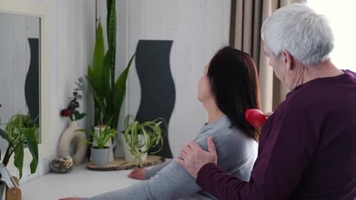 Caring Senior Man Brushing Wife's Hair