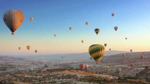 Aerial drone view of colorful hot air balloon flying over Cappadocia at summer sunrise. 4K.