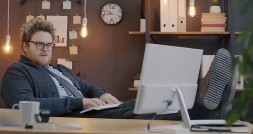 Loop of Stressed Employee Typing and Looking at Computer Screen Working Hard in Illuminated Office