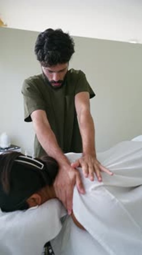 Massoterapeuta masculino dando uma massagem relaxante nas costas