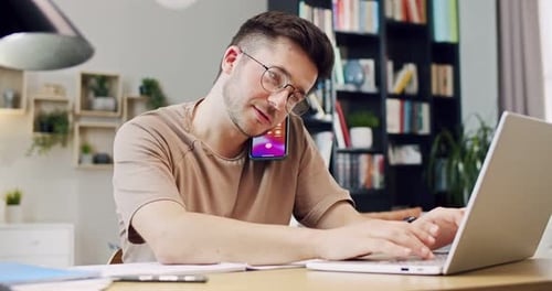 Young Adult Working on Laptop Talking on Phone