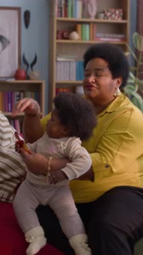 Woman Combs Childs Hair While Sitting on Couch