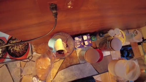 A handheld top-view shot of a milk being poured to a measuring cup until full and pours it next to a