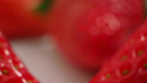 Rotierende reife Erdbeeren auf weißem Hintergrund. Erdbeeren aus nächster Nähe. Makrovideo Rote Erdbeeren