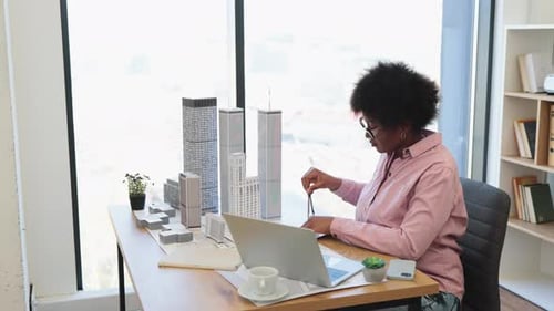African Woman Architect Working on City Model in Office