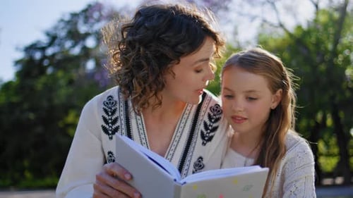 Cute Girl Watching Book Parent at Park Lawn Closeup Mother Reading Fairytale