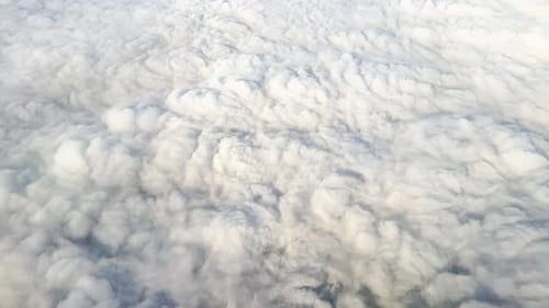 Thick Blanket of Fluffy Clouds Captured From Above During Flight